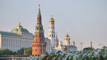 Fototapeta premium Moscow Kremlin architecture and golden domes rising above flowering plants