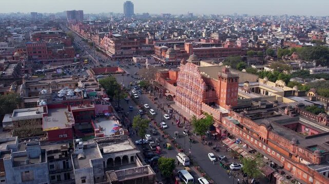 Hawa Mahal with street traffic and city activity showing urban lifestyle and historic architecture in Jaipur, India.