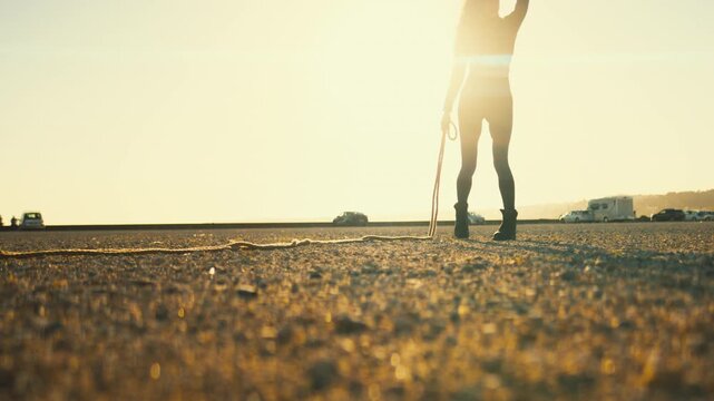 Woman silhouette dancing with a rope at sunset