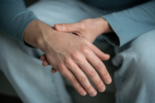 Closeup of man arms holding painful wrist caused by prolonged work on computer, laptop. Carpal tunnel syndrome, arthritis, neurological disease concept. Numbness of hand
