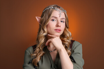 Obraz premium Beautiful girl dressed as elf on brown gradient background