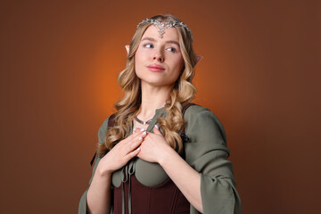 Obraz premium Beautiful girl dressed as elf on brown gradient background