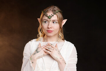 Obraz premium Beautiful elf girl on black background with smoke