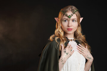 Obraz premium Beautiful elf girl on black background with smoke, space for text