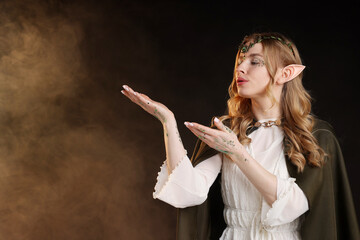 Obraz premium Beautiful elf girl on black background with smoke, space for text