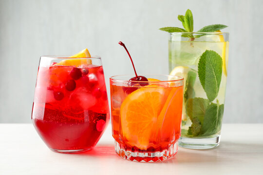 Tasty refreshing cocktails on light table, closeup