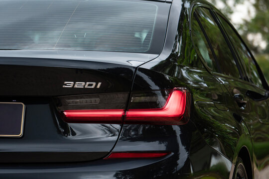 Black BMW 320i rear taillight and badge close up, Luxury sedan rear end branding details outdoors