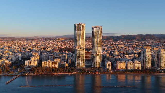 Aerial drone view of Limassol coastline featuring twin towers and Mediterranean Sea