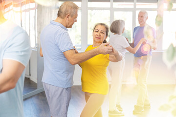 Fototapeta premium Elderly man and elderly woman dance ballroom dance waltz in studio