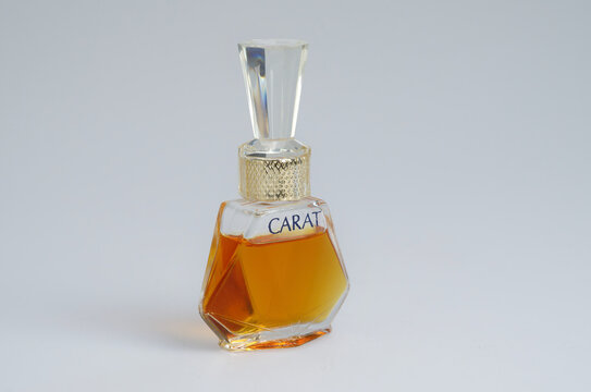 Cologne, Germany March 28 2024: Elegant diamond-shaped glass miniature bottle of Carat perfume. Vintage fragrance by Muelhens, isolated on a light grey background