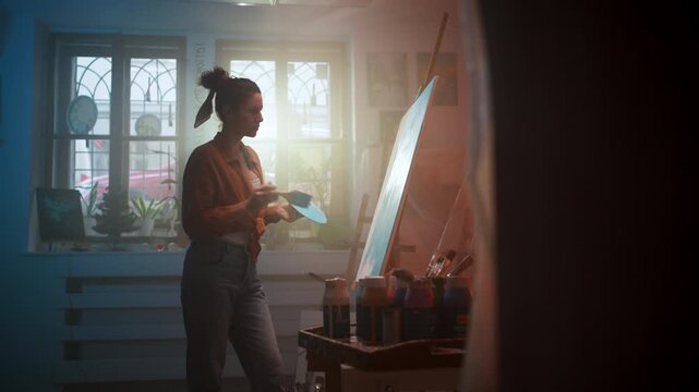 Woman Artist Working Near Sunlight And Plants, Casual Female Painter In Loft With Jars And Foliage