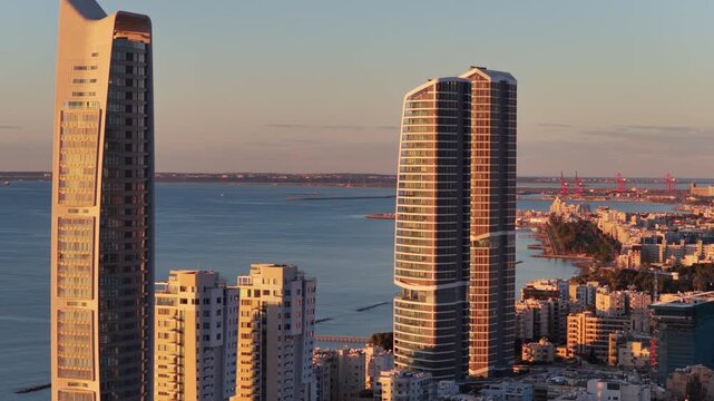 Aerial drone view of twin high rise towers along the Limassol waterfront at sunset