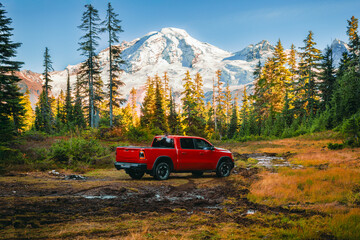 Red off-road truck in alpine meadow with Mount Baker at sunset, Washington © Victoria Nefedova
