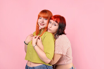 Lovely lesbian couple on pink background. LGBT concept