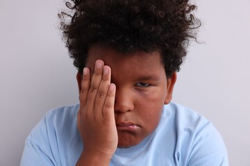 Fototapeta premium Resentful little boy on light grey background