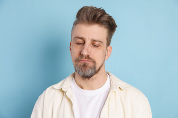 Fototapeta premium Resentment. Frustrated man on light blue background