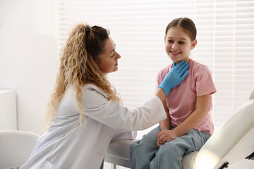 Obraz premium Endocrinologist in medical gloves examining girl's thyroid gland in clinic