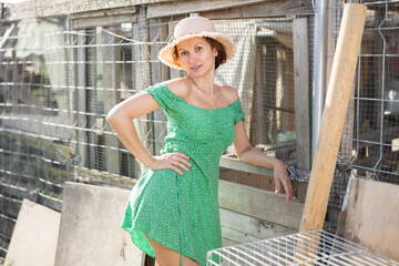 Young girl with bare shoulders stands against background of vegetable garden, poses in countryside, demonstrates sexuality, attractiveness, feminine charms © JackF