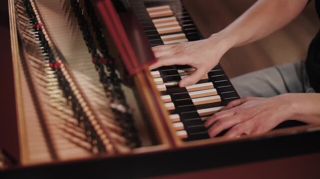 Musician hands playing on a vintage double-manual harpsichord stylized as an organ