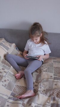 Young Girl Engages In Gaming. Caucasian Female Intently Concentrating During Her Solitary Video Game Activity. Young Woman Fully Immersed And Enjoying Her Casual Gaming Experience Alone At Home