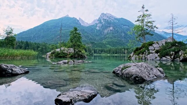 Peaceful Hintersee lake in Bavaria featuring clear water reflections and the Hoher Goll peaks.