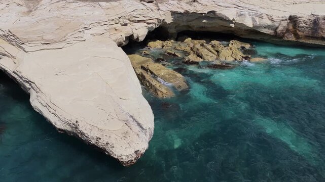 Aerial drone view of white cliffs meeting turquoise water near Ayia Napa, Cyprus
