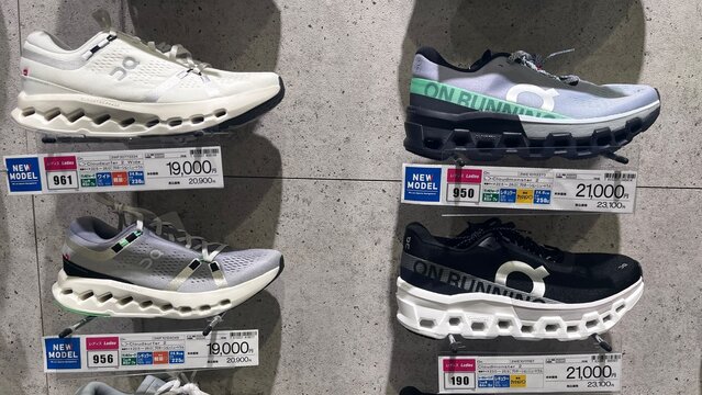 On Running Cloudsurfer and Cloudmonster 2 flagship sneakers displayed with retail price tags in a Japanese sporting goods store - Osaka, Japan, October 15, 2024