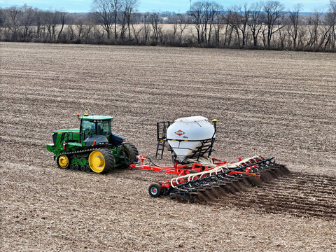 Roscoe, Illinois, April 1, 2026, John Deere 9560RT tracked tractor pulling a Kuhn Gladiator 1205 strip-tilling and fertilizing for spring planting.