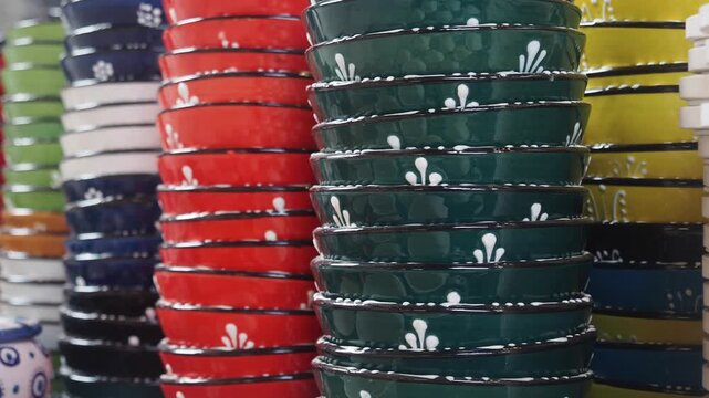 Stacks of colorful ceramic bowls with decorative patterns in vibrant hues.