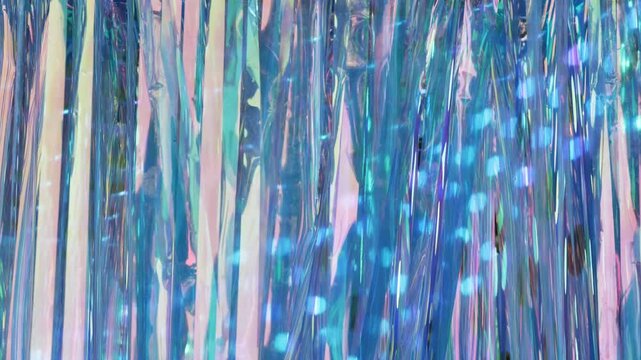Iridescent tinsel stream creating an abstract shimmering light background