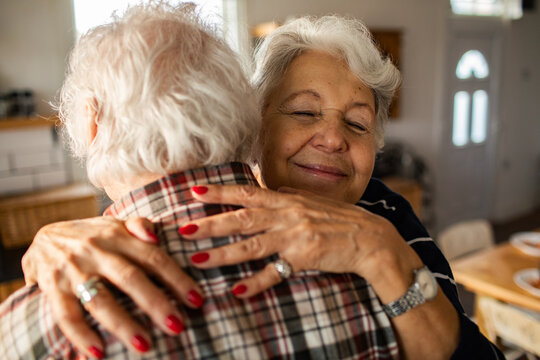 Senior couple hugging affectionately in home kitchen