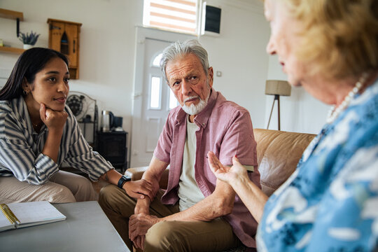 Social worker counseling senior couple at home