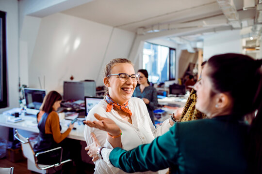 Two coworkers celebrating in a fashion design studio