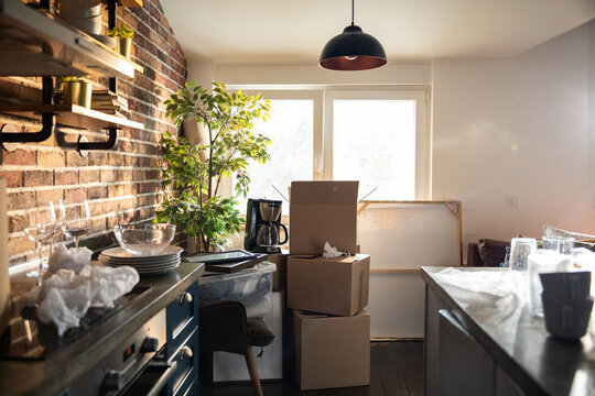 Moving boxes in a sunny apartment kitchen