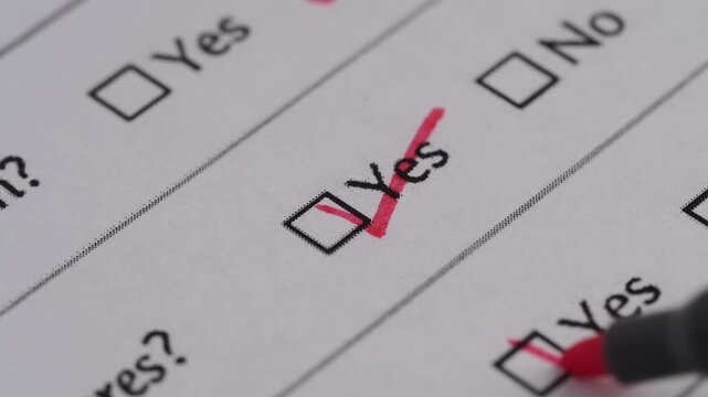 Red marker pen ticking yes check box on survey form with close up macro footage motion shot.