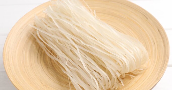 Uncooked rice noodles on white table, closeup