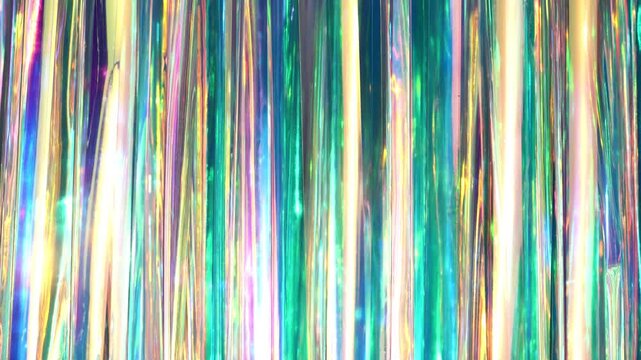 Iridescent tinsel background creating a holographic and shimmering abstract texture