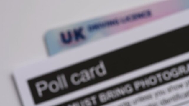 A focus in clip of a government election poll card and a driving licence for identification.