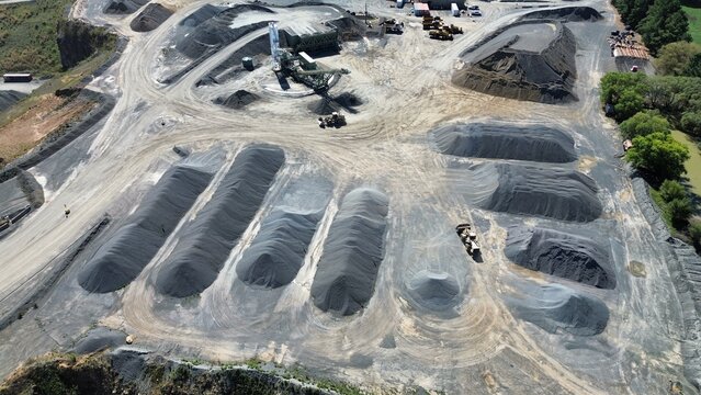 Aerial drone view of quarry stockpiles with organized gravel and aggregate materials at mining site