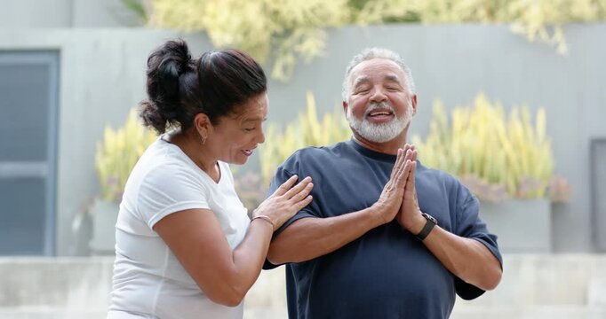 Senior African American couple teasing on patio, woman putting hand on his arm, man laughing