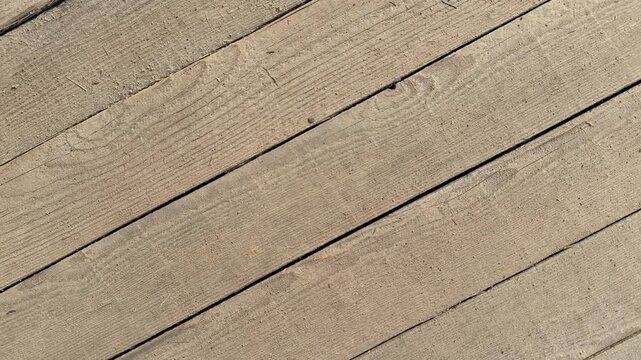 Diagonal oak plank floor closeup showcasing textured grain, dark seams, warm beige tones, subtle wear and tight panel joints.