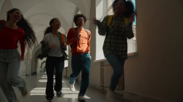 Happy multiracial students running laughing university corridor rushing smiling four diversity friends African Hispanic man male guy women female girls college school holiday pass exam late to class