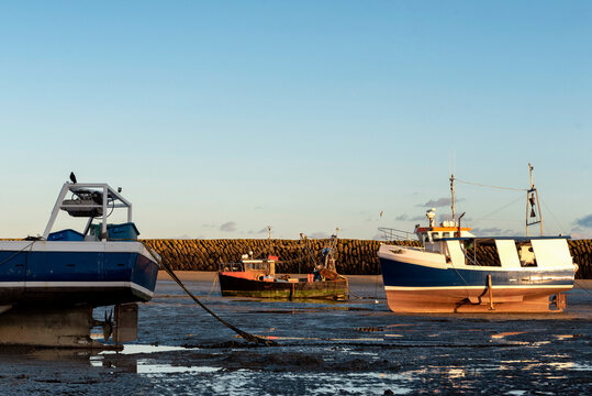 Old fishing boat in Folkestone harbour with stone breakwater in the background