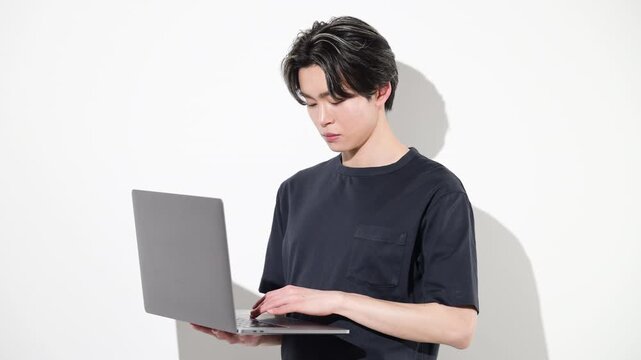 ノートパソコンで作業する若いフリーランスエンジニアやデザイナーなどの白背景　効率化や時短でaiを使うイメージの動画