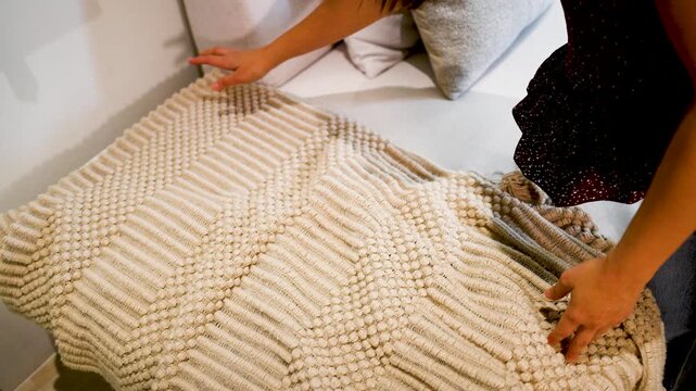 Close Up of Hands Smoothing a Beige Woven Textured Rug