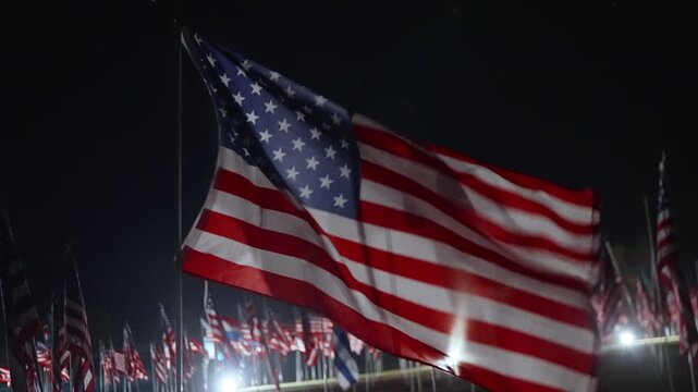 Close up American flag waving at night in Malibu, California, USA honoring September 11 memorial, strong lighting highlighting fabric motion and patriotic atmosphere