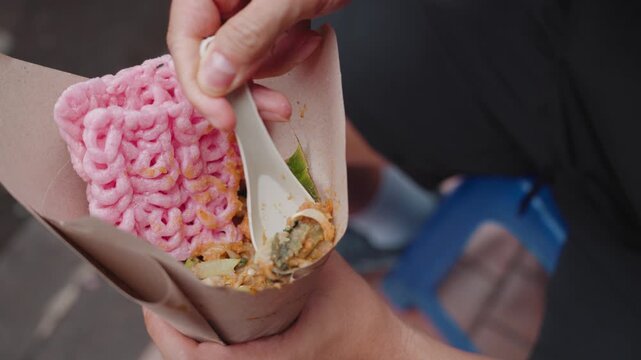 Traditional Indonesian lotek being prepared and served at a street food stall in Bandung, Indonesia. Fresh vegetables mixed with peanut sauce and enjoyed as a local culinary experience in an authentic