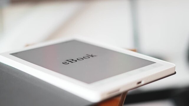 Closeup of ebook device placed on books, blending classic reading with modern tech. Concept learning, digital library, knowledge, comfortable reading environment. Read ebook on go, home, work, on trip