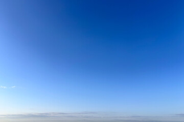 Obraz premium 青空と朝焼けが残る白い雲が広がる晴天の空