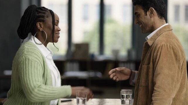 Medium shot of two professionals discussing loan restructuring terms with focused handshake blurred background highlighting agreement on extended tenor options.